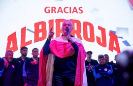 Gustavo Alfaro en el podio, vestido con colores de la bandera paraguaya, mientras es escuchado por todo el plantel de la Selección Nacional.