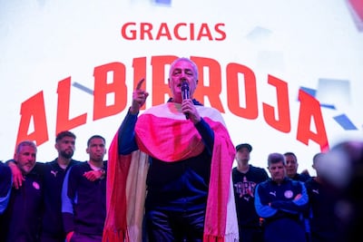 Gustavo Alfaro en el podio, vestido con colores de la bandera paraguaya, mientras es escuchado por todo el plantel de la Selección Nacional.
