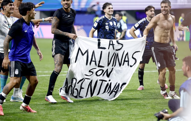 Futbolistas argentinos festejan con la pancarta tras haber derrotado a Inglaterra.
