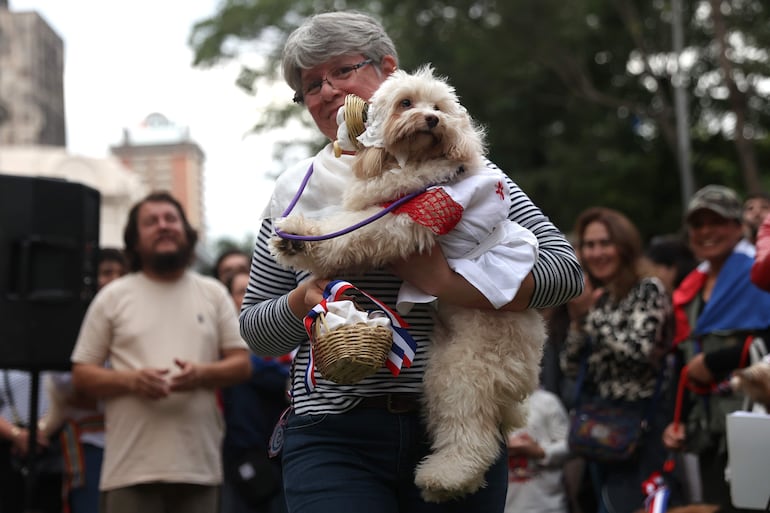 Una mujer sostiene un perro durante el desfile de la celebración del Jagua Patriotaeste jueves, en Asunción.