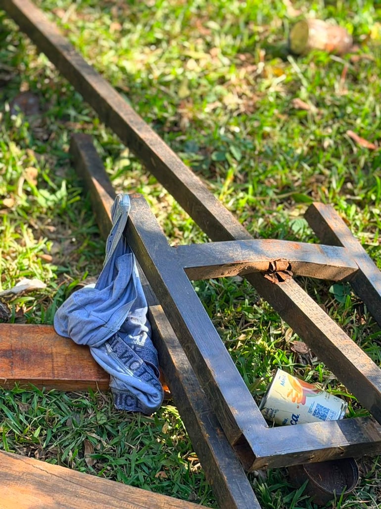 Marco metálico negro y tablones de madera en un área verde con pasto. No hay personas visibles.