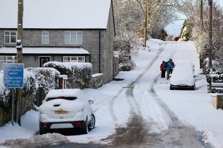Personas descienden por una colina nevada en Mold, Gran Bretaña. Zonas de Escocia, Gales e Inglaterra se encuentran bajo alertas meteorológicas amarillas y ámbar de la Oficina Meteorológica por nieve y hielo, a medida que el aire frío ártico procedente de Escandinavia se desplaza por el Reino Unido.