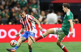 Alan Benítez (i), jugador de la selección de Paraguay, disputa el balón en un partido frente a México por la Fecha FIFA en el estadio Alamodome, en San Antonio, Texas, Estados Unidos.