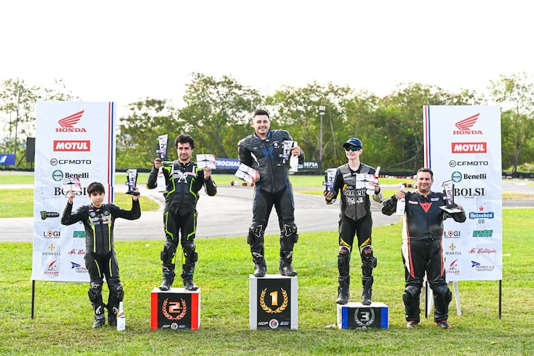Los cinco primeros pilotos de la categoría GP Light celebran en el podio con sus respectivos trofeos.