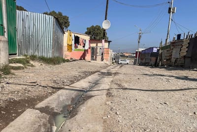 Aguas residuales corren por un canal en una calle del asentamiento informal de Barcelona, en Gugulethu, Ciudad del Cabo, el 7 de septiembre de 2026. El lugar está situado a menos de dos kilómetros del terreno donde se proyecta construir un gran centro de datos, cerca del aeropuerto internacional de Ciudad del Cabo.