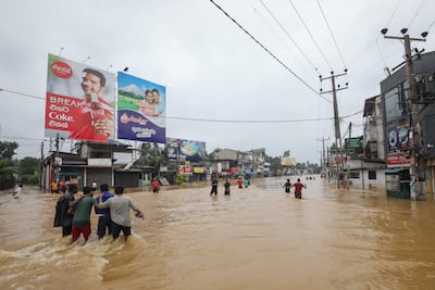 Víctimas de las inundaciones en Sri Lanka caminan por una carretera inundada durante las fuertes lluvias en un suburbio de Colombo, Sri Lanka.