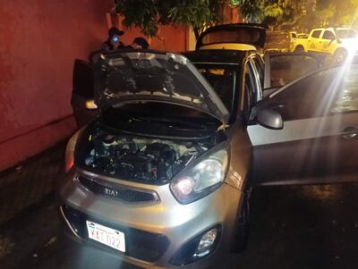 Agentes de Investigaciones verifican el interior del automóvil abandonado en plena calle del barrio San Vicente de Asunción, en uno de los procedimiento srealizado hoy tras la pista de los autores del asesinato del hincha del Olimpia, ocurrido el domingo pasado en San Lorenzo.