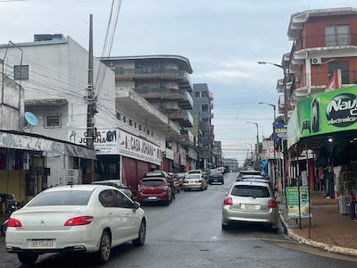 Ambiente urbano sin personas, calle pavimentada y tienda 'Nayú' en electrónica con toldo verde.