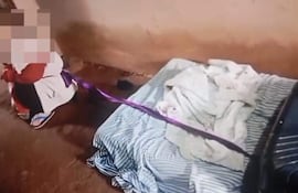 Niño de dos años en un entorno desolador, con un aspecto visiblemente angustiado y atado, evidenciando maltrato.
