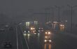 Los viajeros conducen en medio de una densa niebla tóxica en Nueva Delhi el 21 de octubre de 2025, mientras la bruma envolvía el horizonte de la ciudad un día después de Diwali, el festival hindú de las luces.