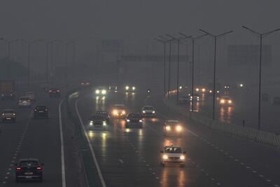 Los viajeros conducen en medio de una densa niebla tóxica en Nueva Delhi el 21 de octubre de 2025, mientras la bruma envolvía el horizonte de la ciudad un día después de Diwali, el festival hindú de las luces.