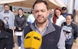 Hombres y mujeres en protesta frente a un hospital, algunos con camisetas que dicen 'UN PASO ATRÁS', expresiones serias.