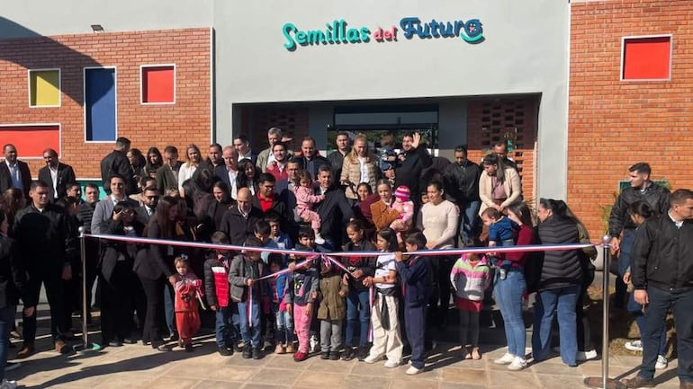 Francisco Javier Pereira Rieve y Santiago Peña, con sonrisas, observan la ceremonia de inauguración del centro, rodeados de niños y adultos.