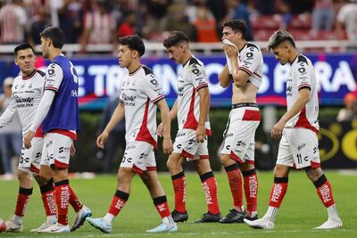 Futbolistas del Atlas, entre ellos el paraguayo Diego González (primero de la derecha), se retiran del campo cabizbajos por la paliza recibida contra el Chivas en el clásico tapatío.