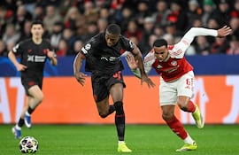 El brasileño del Arsenal Gabriel Magalhaes (D) y el camerunés del Bayer Leverkusen Christian Kofane luchan por el balón durante el partido de ida de los octavos de final de la UEFA Champions League entre el Bayer 04 Leverkusen y el Arsenal en Leverkusen.
