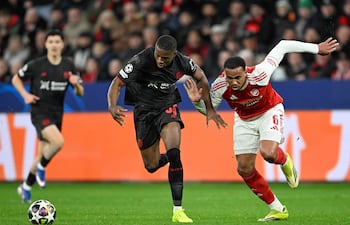 El brasileño del Arsenal Gabriel Magalhaes (D) y el camerunés del Bayer Leverkusen Christian Kofane luchan por el balón durante el partido de ida de los octavos de final de la UEFA Champions League entre el Bayer 04 Leverkusen y el Arsenal en Leverkusen.