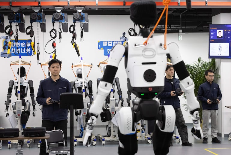 Un empleado controla un robot que corre sobre una cinta de correr durante una visita guiada para medios en la Plataforma Piloto de Verificación de Robots Humanoides de Pekín, en Pekín, China, el 20 de marzo de 2026.