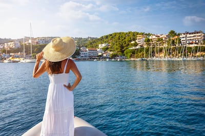 Una turista mira al pueblo de Patitiri en la isla de Alonissos, Espóradas, Grecia.