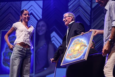Ema Briolli, hija del entrenador uruguayo Marcelo Briolli, le regala un cuadro de su autoría al exentrenador de la selección uruguaya Óscar Washington Tabárez durante el homenaje al Maestro.
