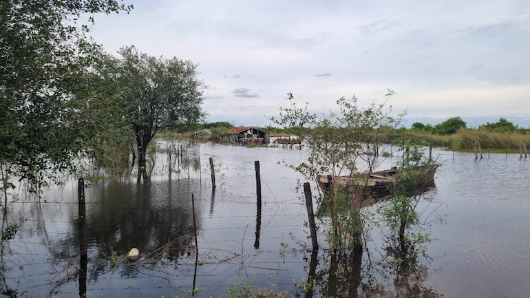 Zona rural de Villa Florida con casa de madera sumergida y bote anclado en agua tras inundación.
