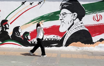 Una mujer camina frente a un mural que retrata al fallecido ayatolá Alí Jameneí, líder supremo de Irán, en Teherán.