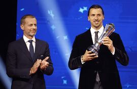 El presidente de la UEFA, Aleksander Ceferin (I), entrega al exfutbolista internacional sueco Zlatan Ibrahimovic el Premio del Presidente 2025 durante el sorteo de la fase de grupos de la Liga de Campeones de la UEFA en el Foro Grimaldi de Mónaco.