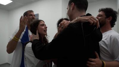 El rehén Guy Gilboa-Dalal, de espaldas, se reúne con su familia al ser liberado. 