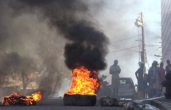 Al menos una docena de personas murieron cuando miembros de bandas atacaron la prisión principal de la capital de Haití, lo que provocó una fuga de varios miles de reclusos.