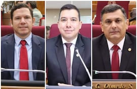 Diego Candia y Edgar Olmedo en trajes formales, con corbatas rojas, en ambiente sobrio de salón de sesiones.