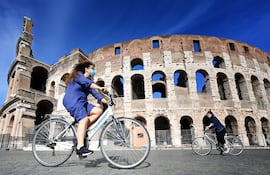 Una mujer circula en bicicleta frente al Coliseo romano. La artrosis en la Edad Media estaba causada por un exceso de trabajo físico, mientras que hoy en día es el sedentarismo lo que la provoca, según un estudio presentado este viernes que analiza restos óseos de los siglos XI y XII encontrados durante las excavaciones efectuadas en el Parque Arqueológico del Coliseo.