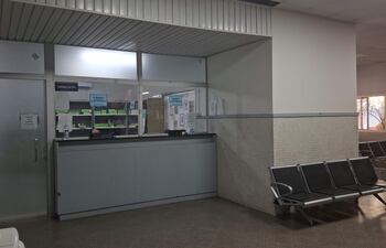 Interior de la farmacia del IPS, con mostrador y estanterías llenas de productos, sin personas visibles.