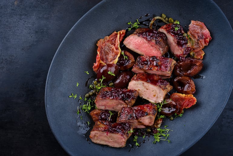 Filete de lomo de liebre salvaje frito con ciruelas, arándanos y tocino.