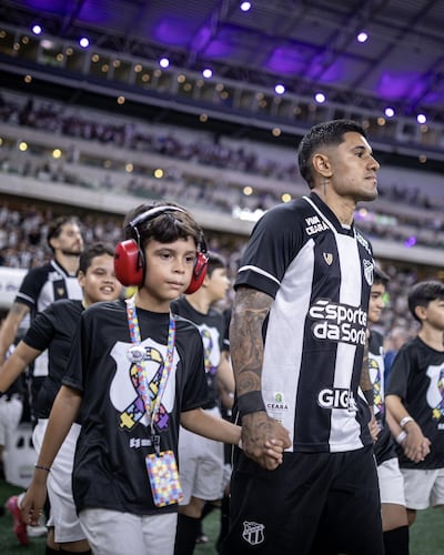Antonio Galeano ingresando al campo de juego acompañado de un niño.
