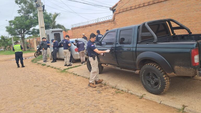 Agentes policiales de distintas agrupaciones verifican la camioneta Nissan Frontier verde en que iban las víctimas del asalto.