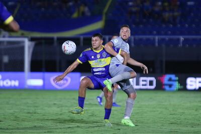 El atacante de 12 de Junio Daniel Valdovinos conserva la posesión del balón ante la marca del volante “conquistador” Luis Matto. (Foto: APF)