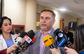 Ever Villalba en traje gris y camisa morada, conversando con dos mujeres periodistas en un entorno de interior.