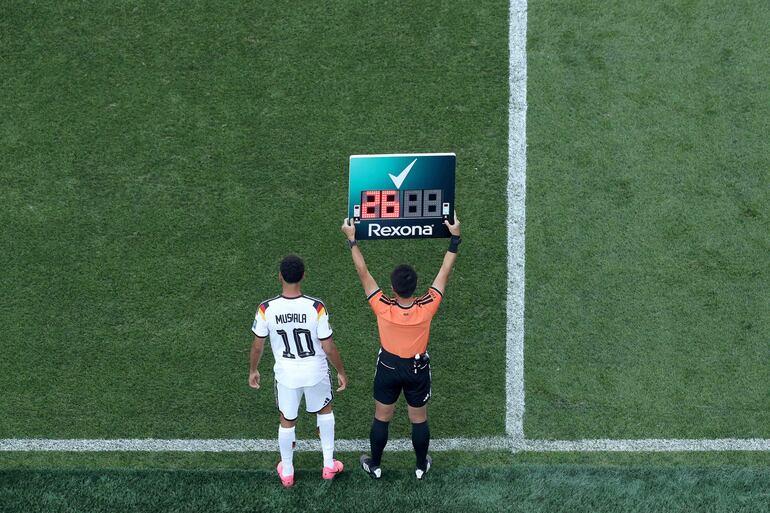 El cuarto árbitro Ning Ma levanta el tablero de sustituciones de Rexona durante el partido de los dieciseisavos de final de la Copa Mundial de la FIFA 2026 entre Alemania y Paraguay en el Boston Stadium.