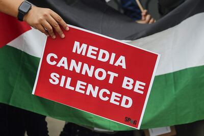 Un periodista con un cartel que reza "Los medios no pueden ser silenciados" durante una manifestación por los reporteros en Gaza, el pasado sábado en Kuala Lumpur, Malasia.