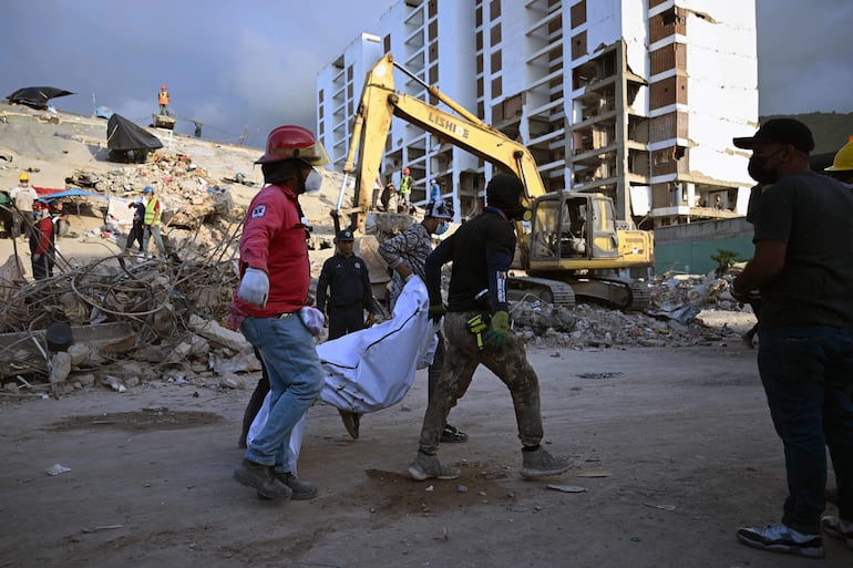 Equipos de rescate transportan el cuerpo de una víctima recuperado de entre los edificios derrumbados en Caraballeda, estado de La Guaira (Venezuela)