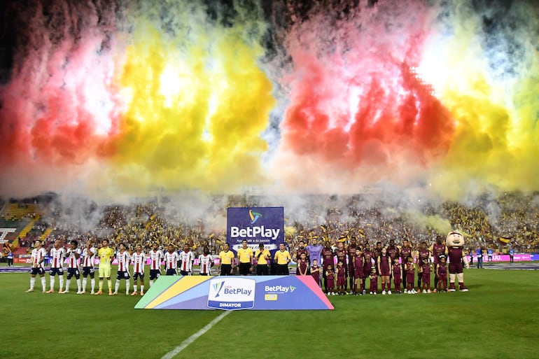 Los jugadores de Tolima y Junior forman en la previa de la final de vuelta del torneo Finalización 2025 de Colombia en el estadio Manuel Murillo Toro, en Ibagué, Colombia.