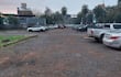 Estacionamiento al aire libre con vehículos de diferentes colores, bajo un cielo nublado y sin actividad humana.