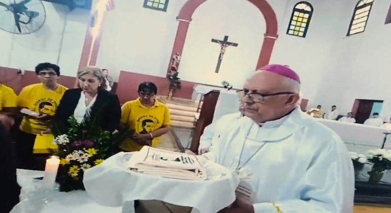 Mons. Celestino Ocampo en hábito religioso sostiene la reliquia, acompañado de personas de la hermandad del padre Julio César Duarte Ortellado.