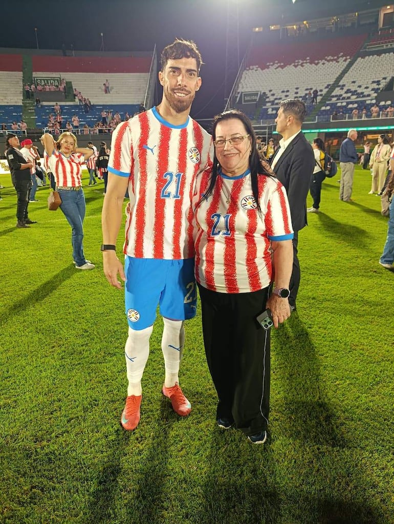 Feliciana Stumpf sonríe junto a Gabriel Ávalos, ambos con camisetas de la selección paraguaya en un estadio.