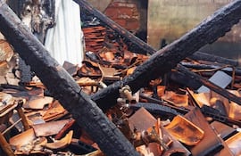 Espacio interior devastado por un incendio, con mobiliario quemado y paredes carbonizadas.