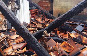 Espacio interior devastado por un incendio, con mobiliario quemado y paredes carbonizadas.