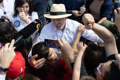 El presidente de Brasil y candidato a la reelección, Luiz Inácio Lula da Silva saluda a sus seguidores a su salida este domingo de un colegio electoral en la ciudad de São Bernardo do Campo (Brasil).