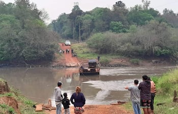 Varias familias dependen de la precaria balsa para cruzar el río Monday.