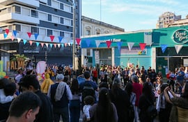 Multitud observando un escenario en la Feria Palmer, con banderines rojos y azules y niños en brazos.