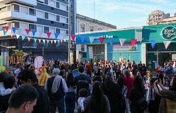 Multitud observando un escenario en la Feria Palmer, con banderines rojos y azules y niños en brazos.