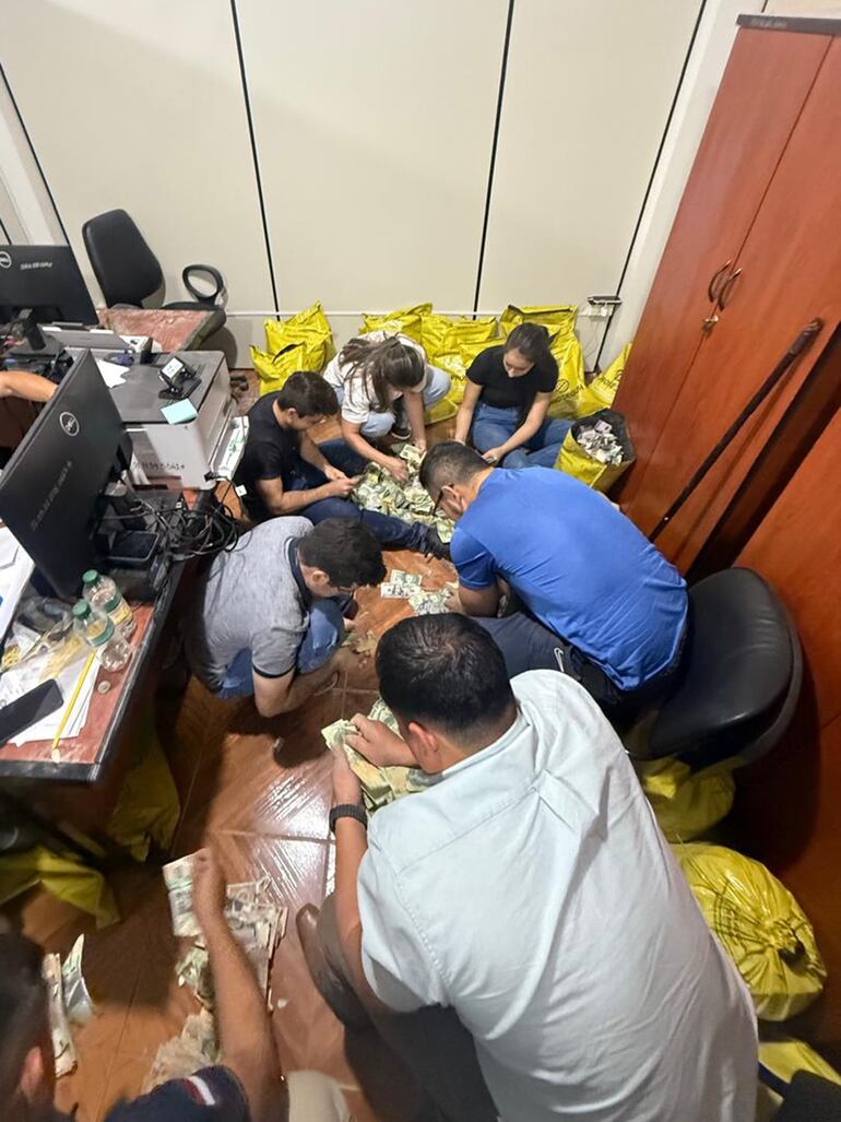 Funcionarios de la Fiscalía y agentes de la Policía durante el conteo de la plata que no pudieron llevarse los asaltantes.